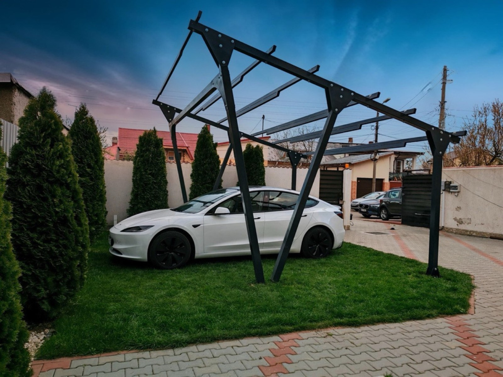 Carport solar HelioPort deasupra unei mașini electrice, la apus